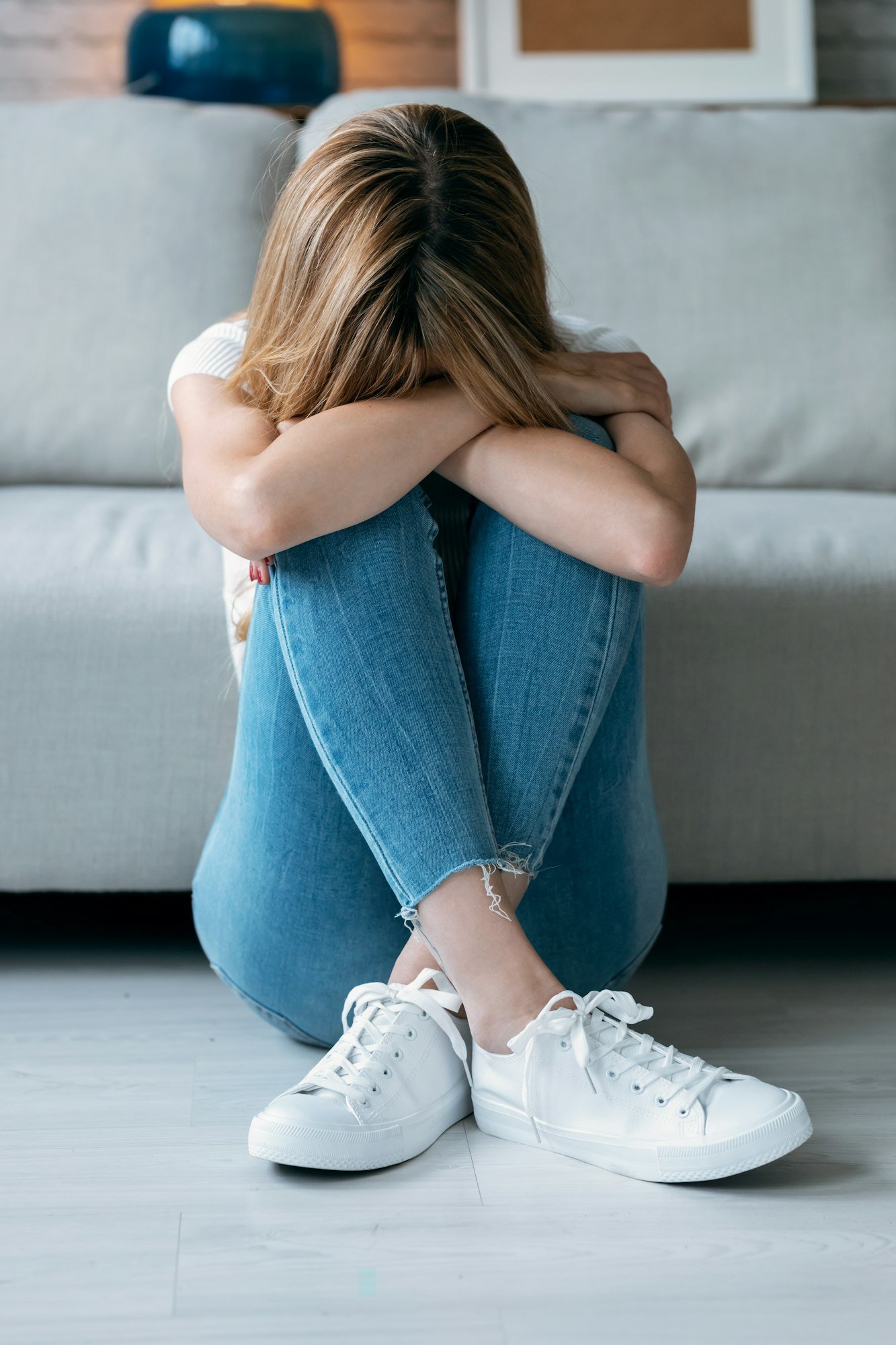 depresive young woman thinking about her problems while sitting on the floor