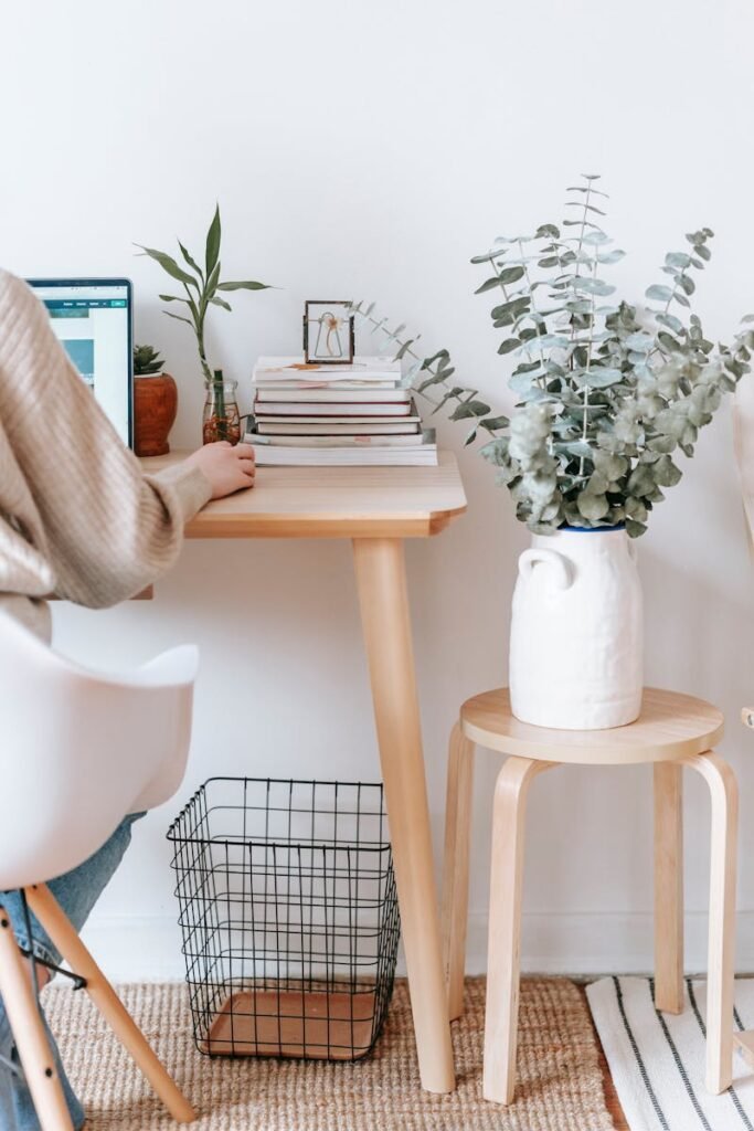 Cozy workspace with a laptop, books, and plants, promoting a relaxed, creative atmosphere.